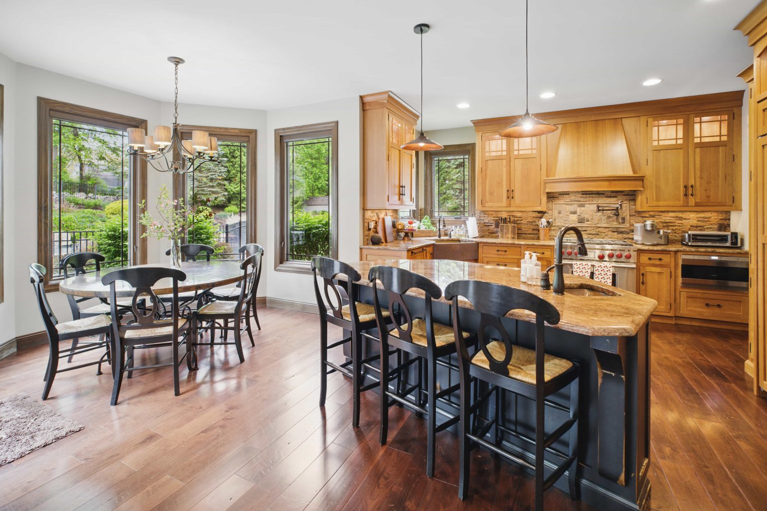 Kitchen and dining area with wood cabinets, an island and large windows