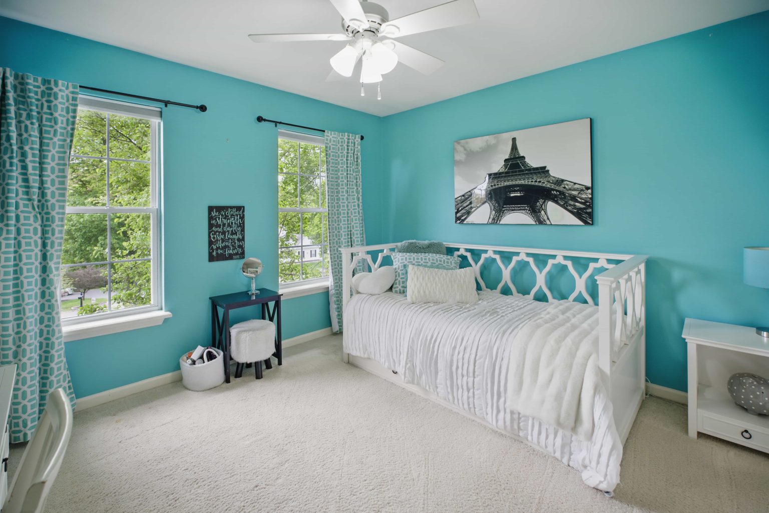 Turquoise bedroom with a white daybed and tall windows